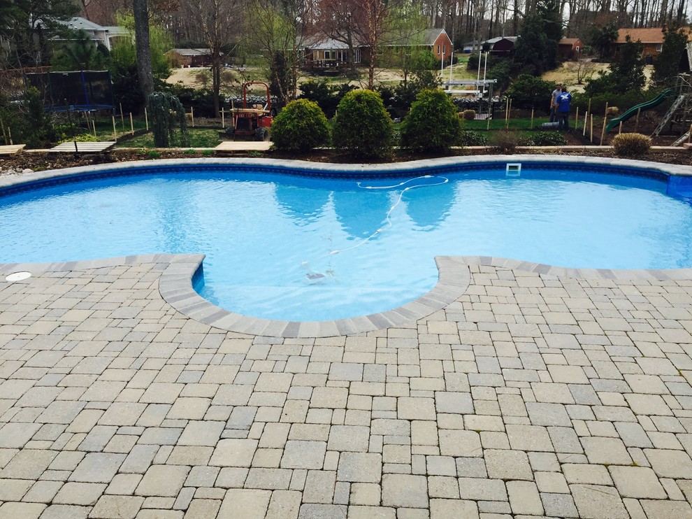 Example of a mid-sized backyard stone and custom-shaped natural pool fountain design