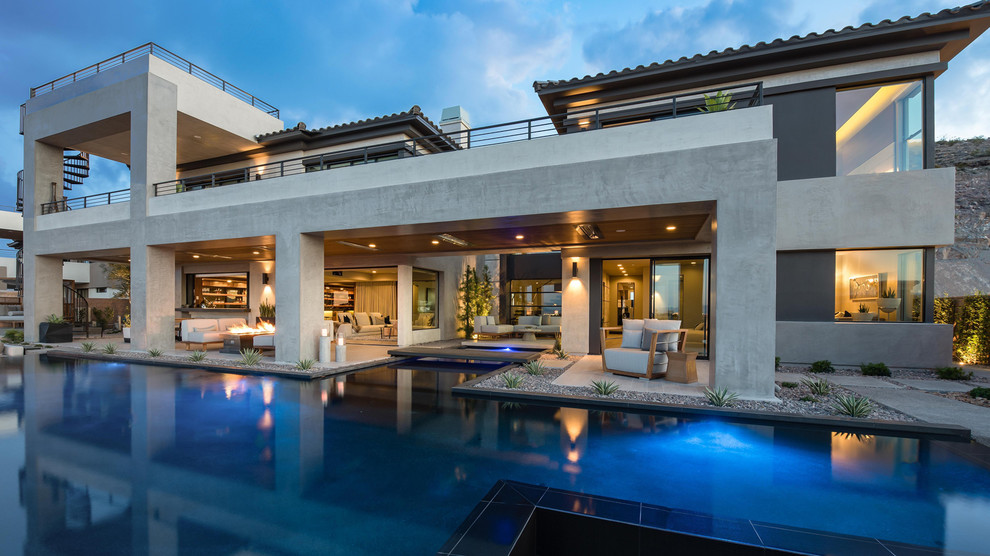 Example of a large trendy backyard concrete paver and rectangular infinity pool fountain design in Las Vegas