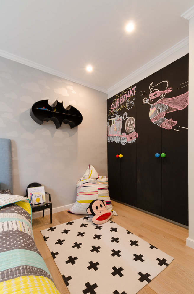Mid-sized contemporary kids' room in Sydney with white walls and light hardwood floors.