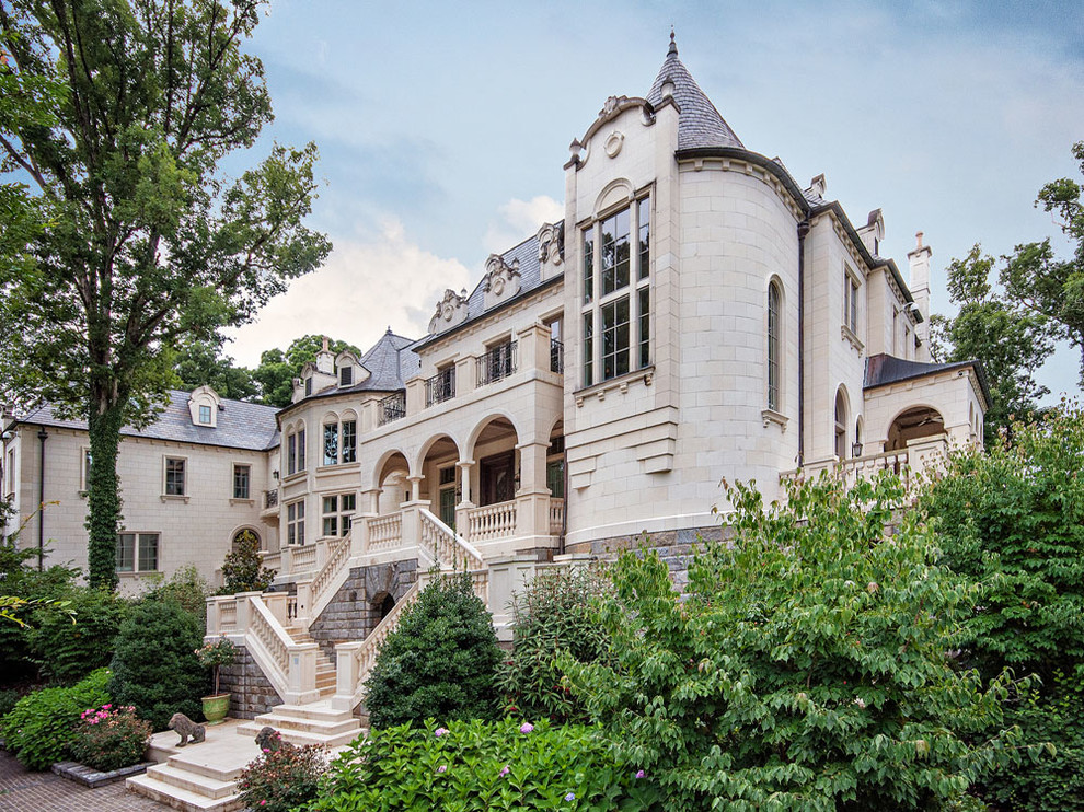 Photo of an expansive mediterranean three-storey beige exterior in Other with stone veneer.