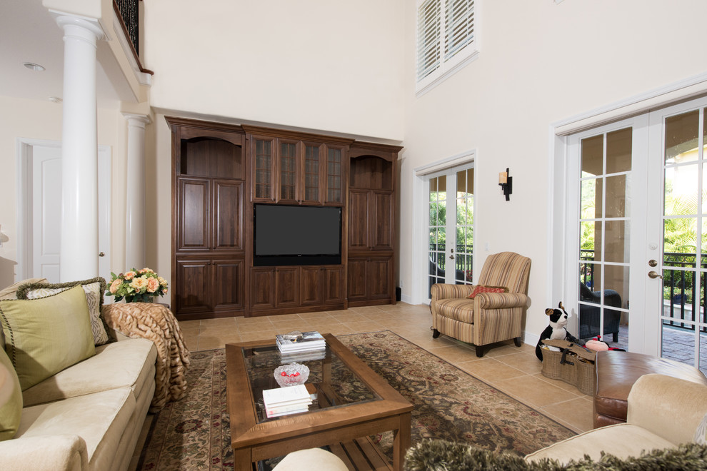 This is an example of a large traditional open concept family room in Tampa with beige walls, porcelain floors and a built-in media wall.