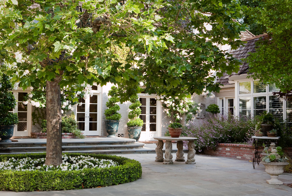 Inspiration for a mid-sized traditional courtyard patio in San Francisco with natural stone pavers.