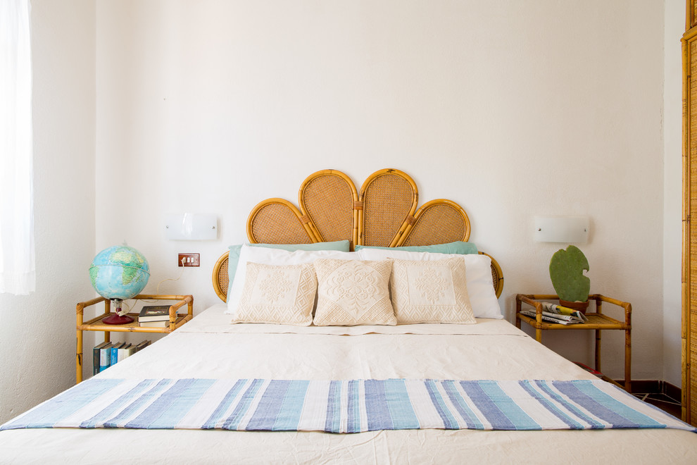 This is an example of a beach style master bedroom in Cagliari with white walls.