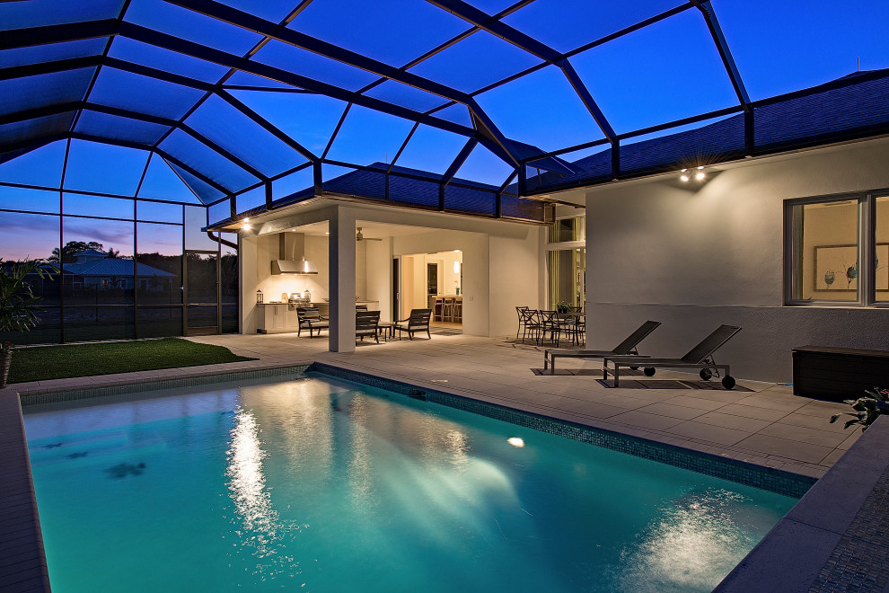 Large contemporary indoor rectangular lap pool in Other with concrete pavers.