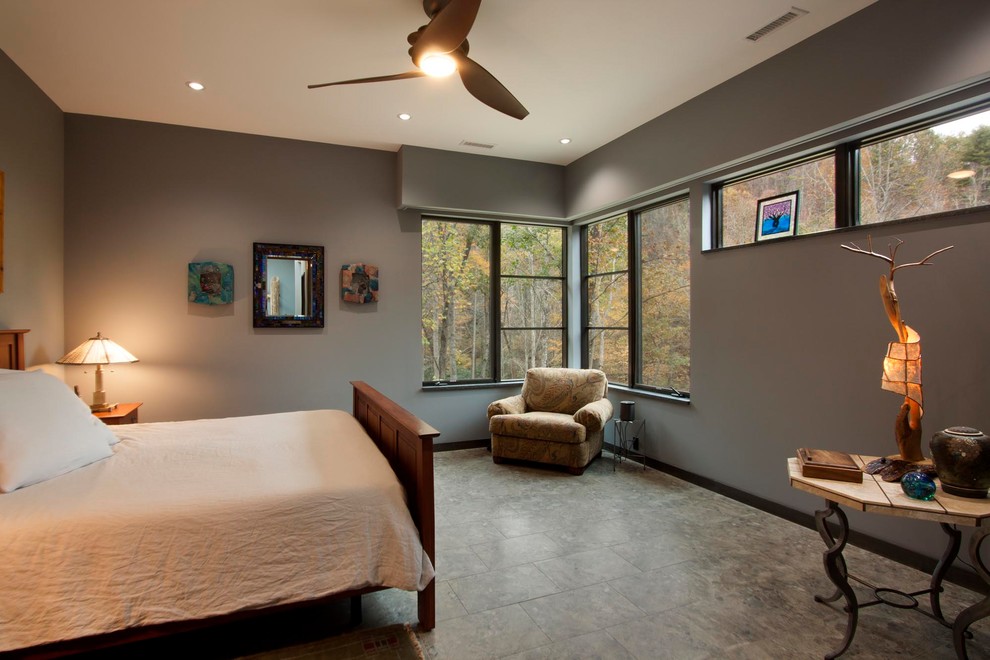 Photo of a large contemporary master bedroom in Other with brown walls, porcelain floors, a two-sided fireplace, a stone fireplace surround and brown floor.