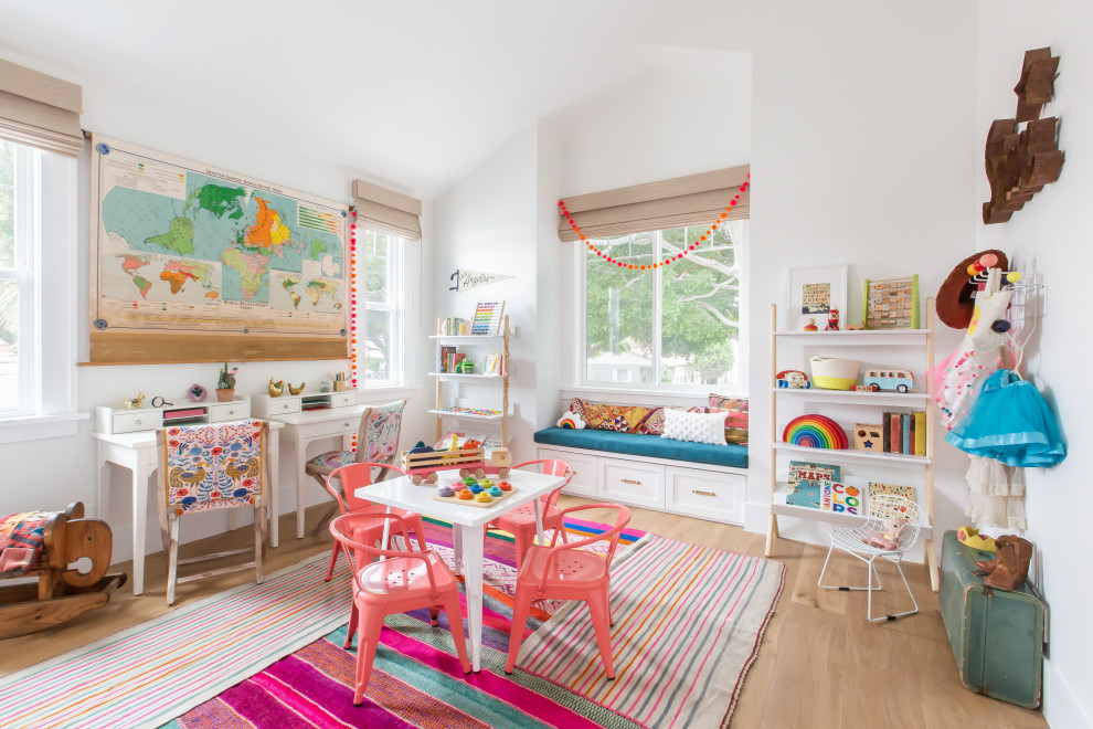 Photo of a beach style kids' room in Los Angeles with white walls, light hardwood floors, beige floor and vaulted.