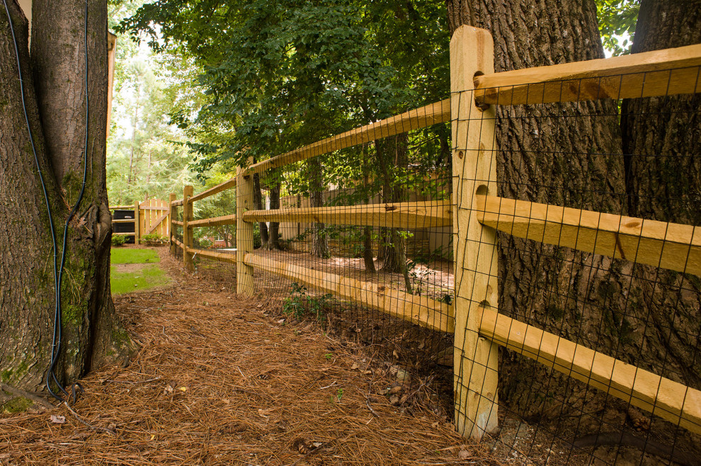 Inspiration pour un jardin arrière chalet avec une clôture en bois.
