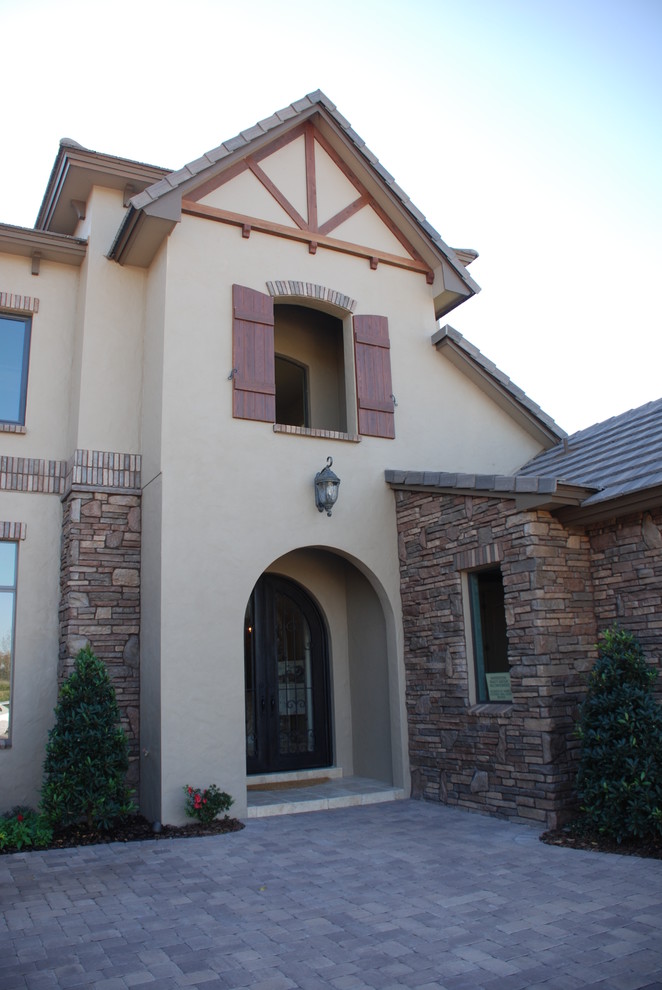 Photo of a large traditional two-storey stucco beige exterior in Orlando with a gable roof.
