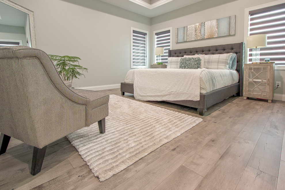 Schlafzimmer mit beiger Wandfarbe, braunem Holzboden, grauem Boden und Kassettendecke in Sonstige