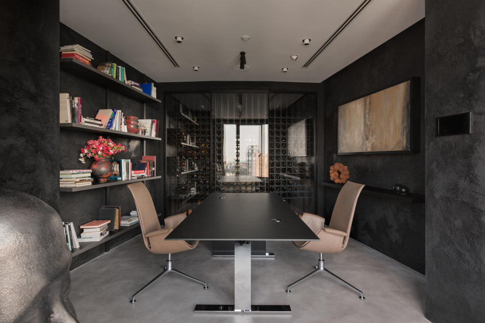 На фото: кабинет среднего размера в стиле лофт с местом для рукоделия, черными стенами, бетонным полом, отдельно стоящим рабочим столом, серым полом и панелями на стенах с