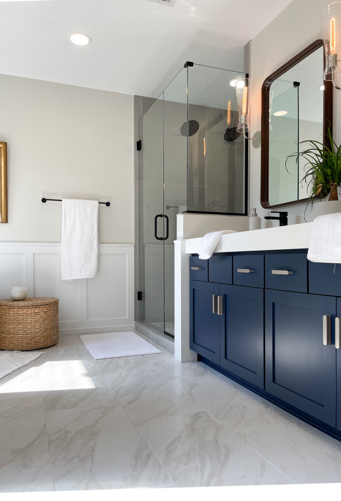 Exemple d'une salle de bain principale moderne de taille moyenne avec des portes de placard bleues, une baignoire indépendante, une douche double, WC à poser, un carrelage gris, des carreaux de céramique, un sol en carrelage de céramique, un lavabo intégré, un plan de toilette en surface solide, une cabine de douche à porte battante, un plan de toilette blanc, meuble double vasque, meuble-lavabo suspendu, boiseries, un mur gris et un sol blanc.