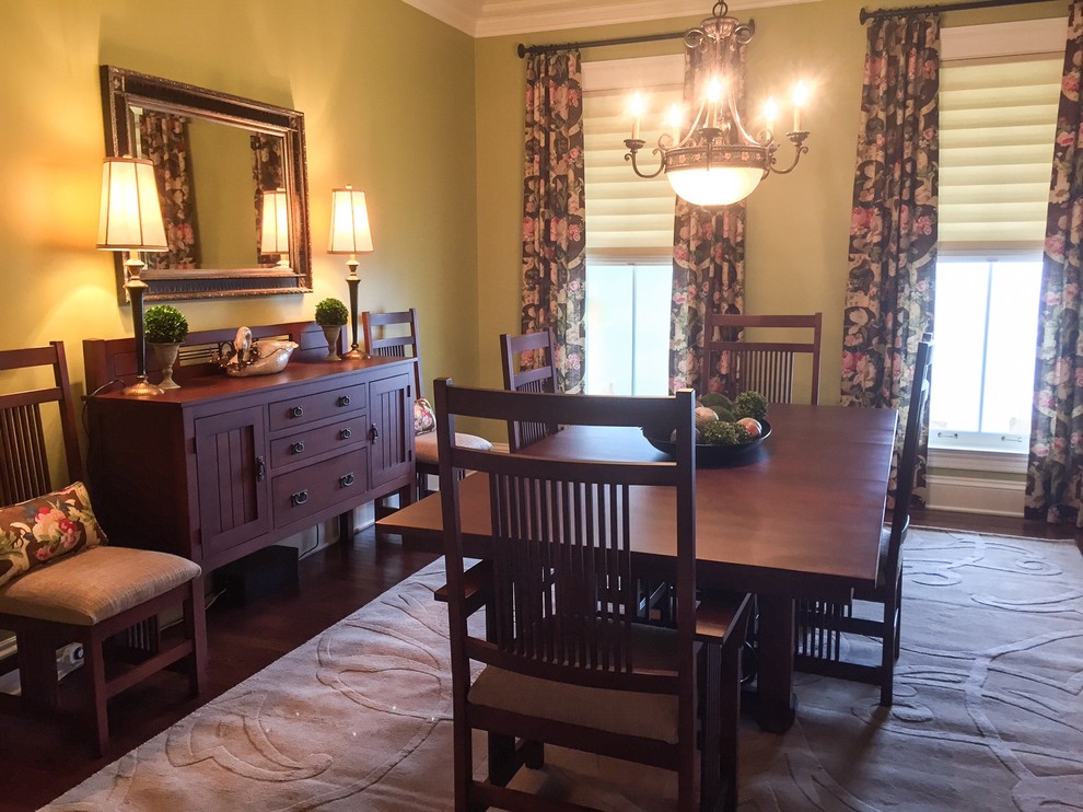 Large country separate dining room in Indianapolis with green walls, dark hardwood floors, no fireplace and brown floor.