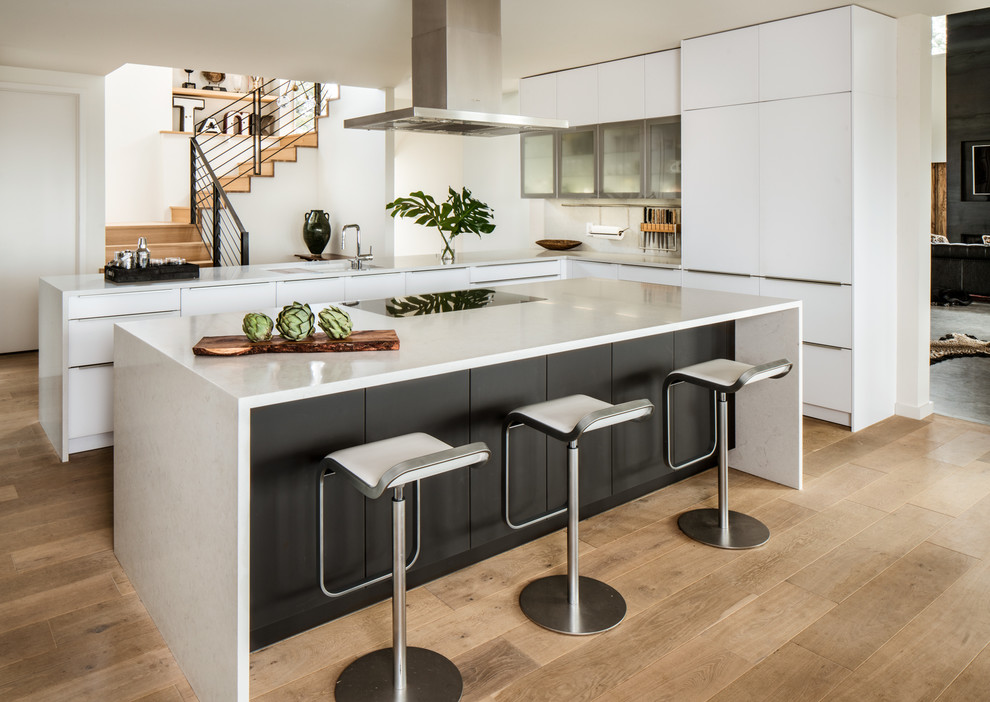 Design ideas for a contemporary l-shaped kitchen in Austin with flat-panel cabinets, white cabinets, light hardwood floors and with island.