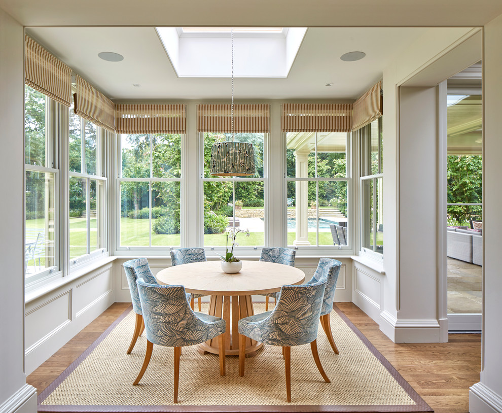 Photo of a transitional dining room in Surrey with beige walls and medium hardwood floors.