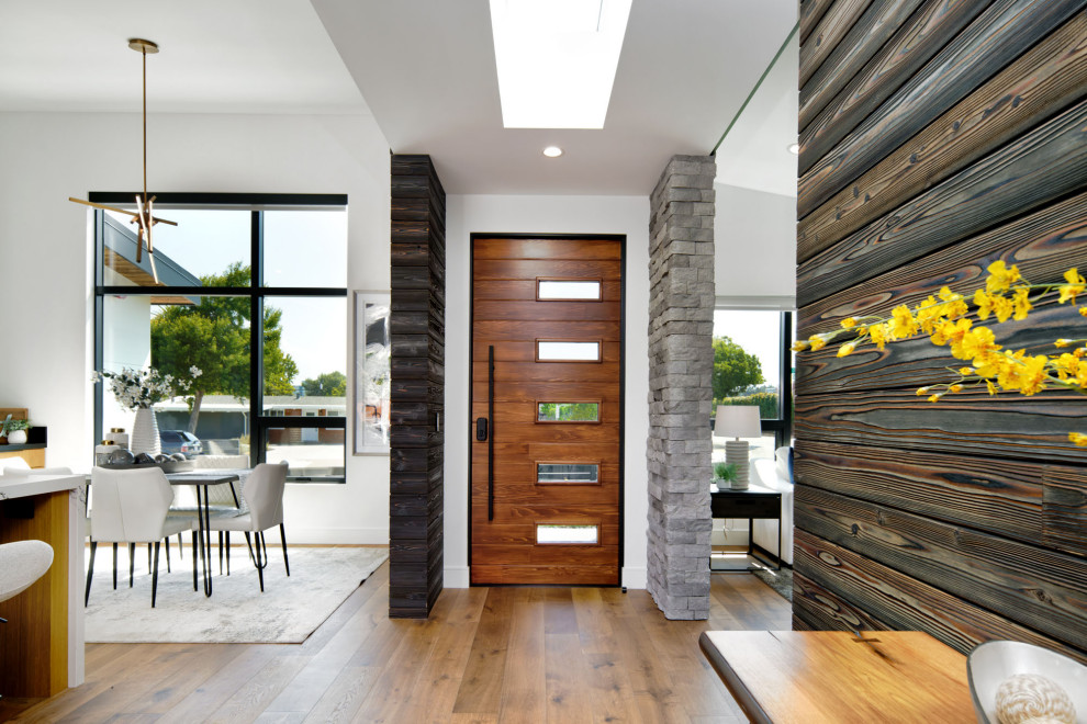 Exemple d'un hall d'entrée tendance en bois de taille moyenne avec un mur blanc, un sol en bois brun, un sol marron, un plafond voûté et une porte en bois brun.