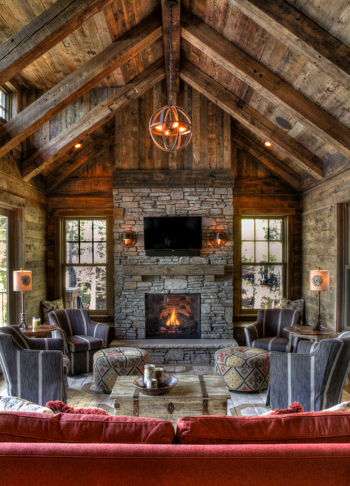 Example of a large mountain style living room design in Minneapolis with a standard fireplace, a stone fireplace and a wall-mounted tv