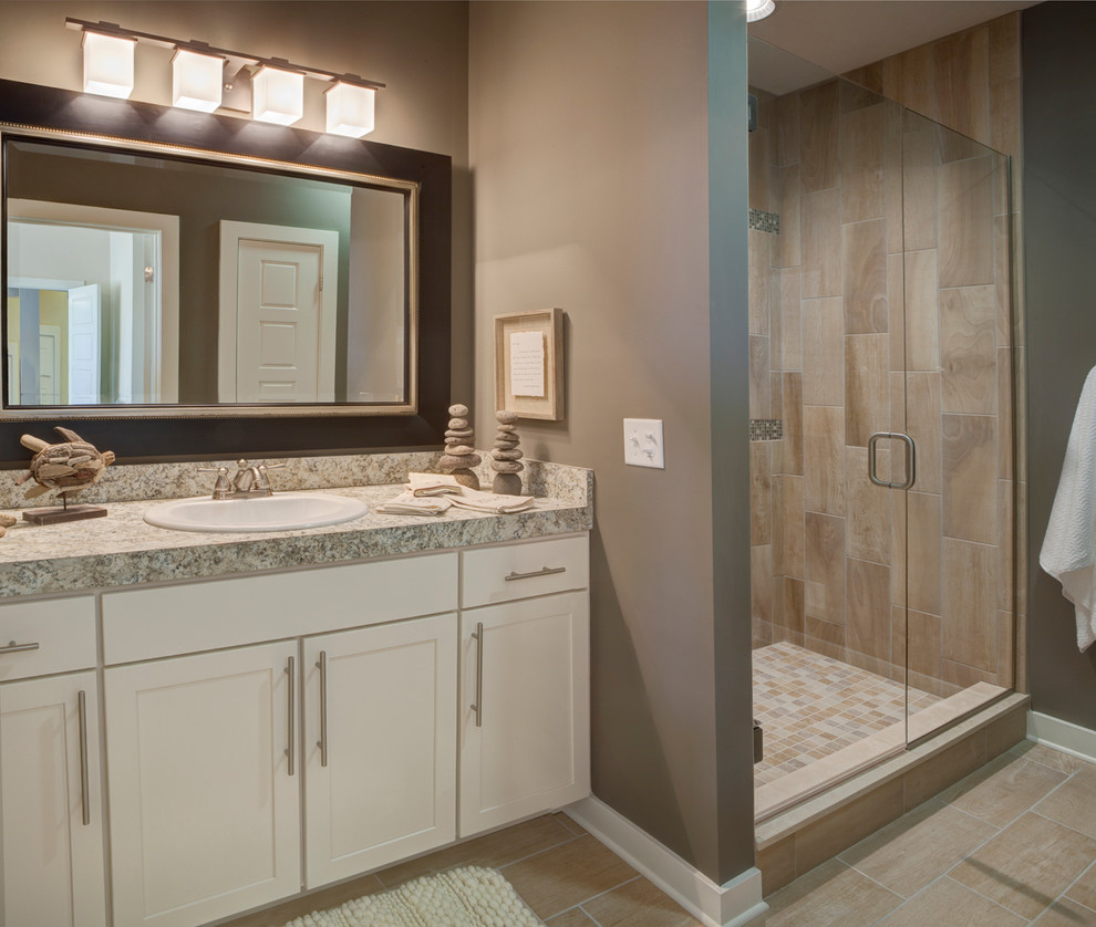 Mid-sized transitional master bathroom in Other with a drop-in sink, shaker cabinets, white cabinets, laminate benchtops, an alcove shower, a one-piece toilet, beige tile, grey walls, ceramic floors and beige floor.