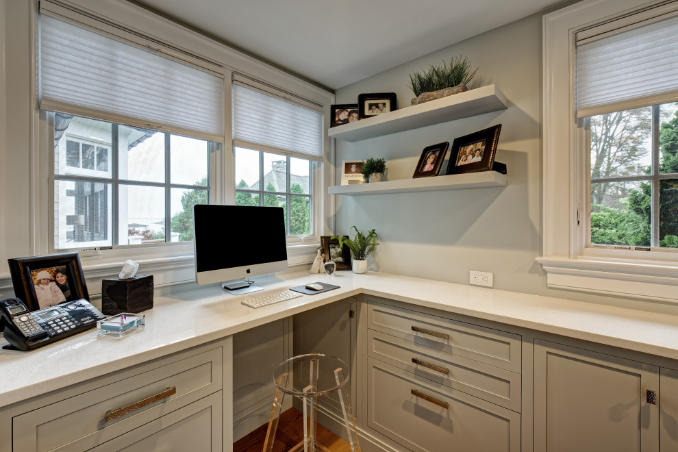 Inspiration for a small coastal home office in New York with grey walls, light hardwood flooring, a built-in desk and brown floors.