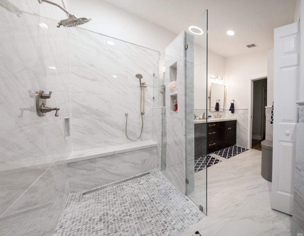 Design ideas for a mid-sized contemporary master bathroom in Tampa with recessed-panel cabinets, dark wood cabinets, a curbless shower, white tile, marble, a drop-in sink, marble benchtops, an open shower, white benchtops, a double vanity and a built-in vanity.