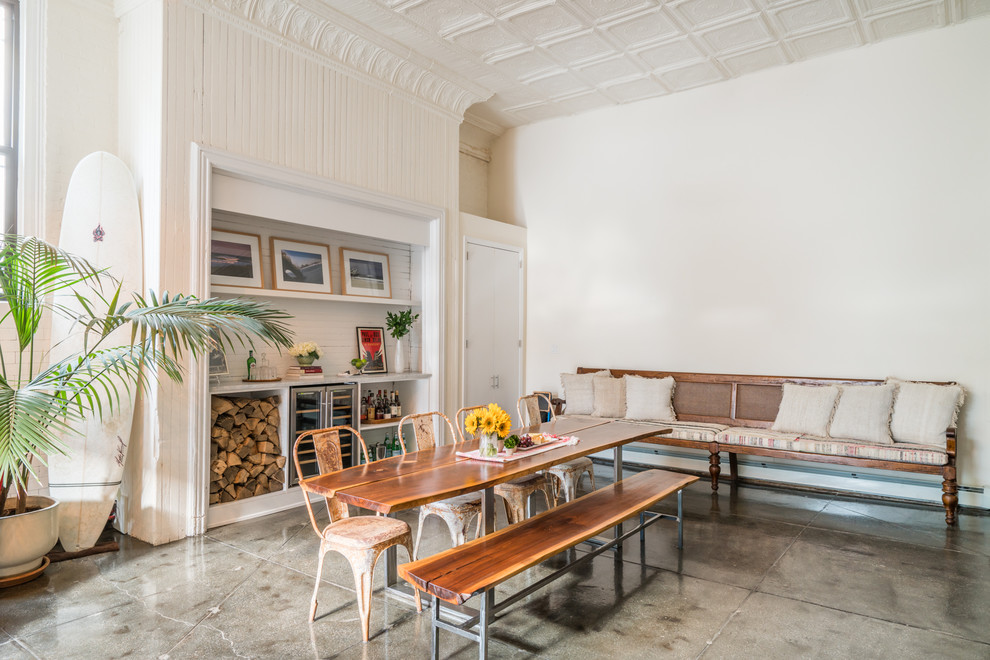 Large eclectic open plan dining in New York with white walls, concrete floors and grey floor.