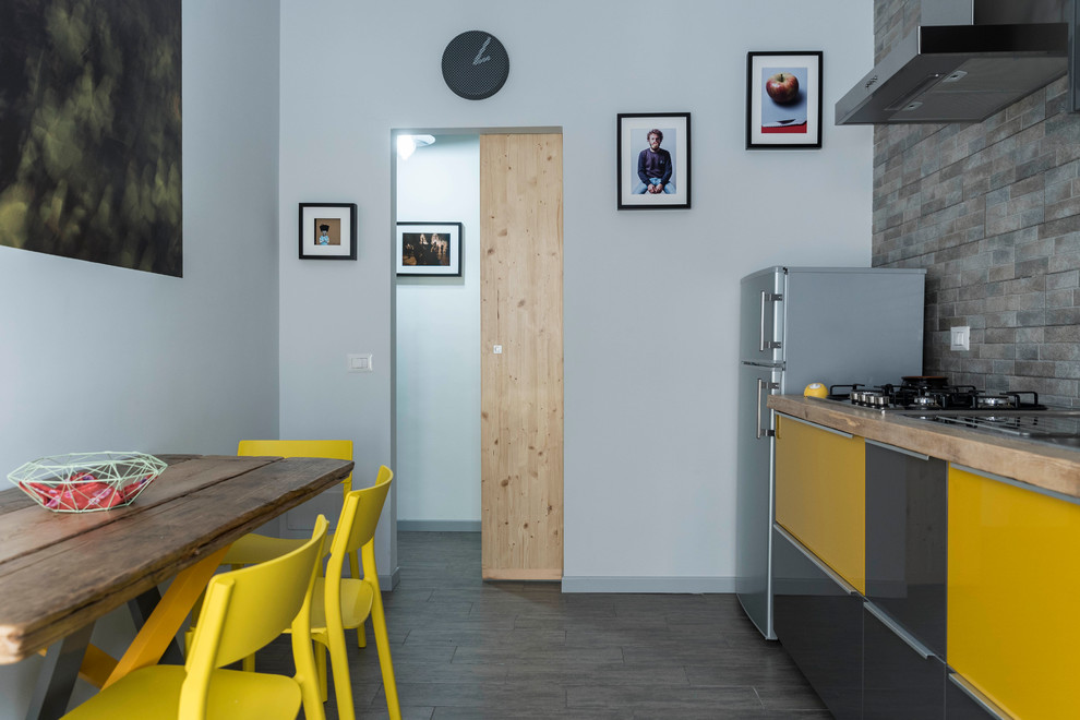 Esempio di una cucina contemporanea di medie dimensioni con lavello da incasso, ante lisce, top in legno, paraspruzzi in lastra di pietra, elettrodomestici in acciaio inossidabile e pavimento in gres porcellanato