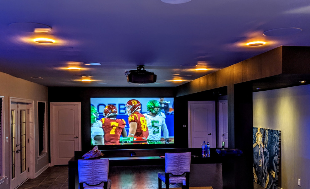 This is an example of a medium sized contemporary enclosed home cinema in Philadelphia with a projector screen.