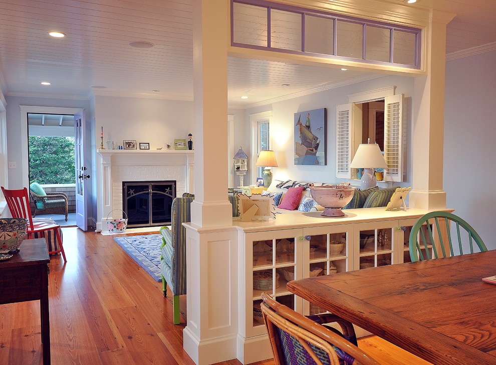 Photo of a beach style dining room in Boston with blue walls, medium hardwood floors and a standard fireplace.