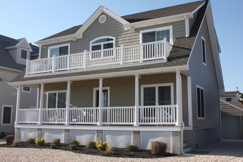Photo of a mid-sized beach style two-storey beige exterior in New York with vinyl siding and a shed roof.