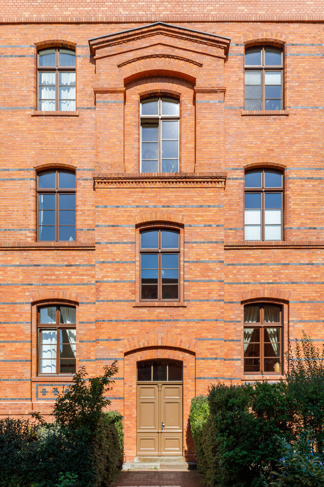 Photo of a traditional front door in Berlin with orange walls, a double front door, a brown front door and brick walls.