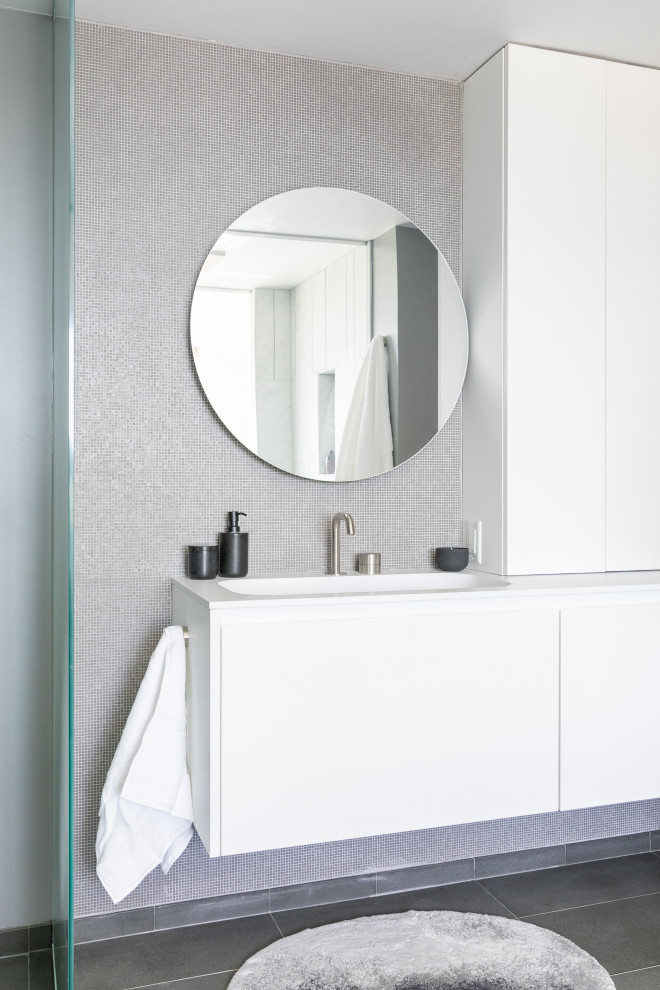 Medium sized contemporary ensuite wet room bathroom in Other with flat-panel cabinets, a one-piece toilet, grey walls, marble flooring, a submerged sink, engineered stone worktops, a hinged door and white worktops.