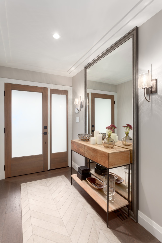 Small transitional medium tone wood floor and brown floor entry hall photo in Vancouver with gray walls and a medium wood front door