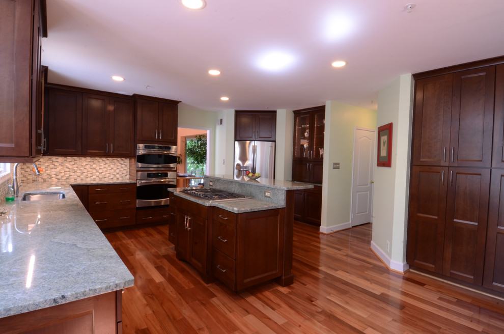 Inspiration for a mid-sized transitional l-shaped dark wood floor and brown floor eat-in kitchen remodel in Baltimore with an undermount sink, shaker cabinets, dark wood cabinets, granite countertops, multicolored backsplash, matchstick tile backsplash, stainless steel appliances and an island