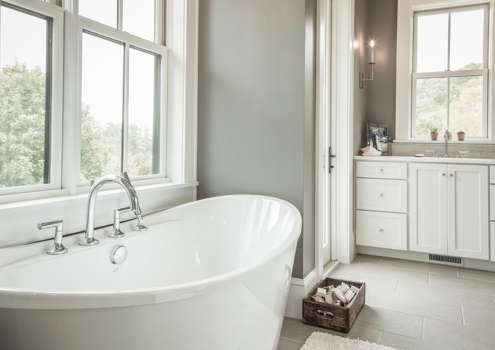 Design ideas for a large country master bathroom in Other with shaker cabinets, white cabinets, a freestanding tub, grey walls, porcelain floors, grey floor, a curbless shower and an undermount sink.
