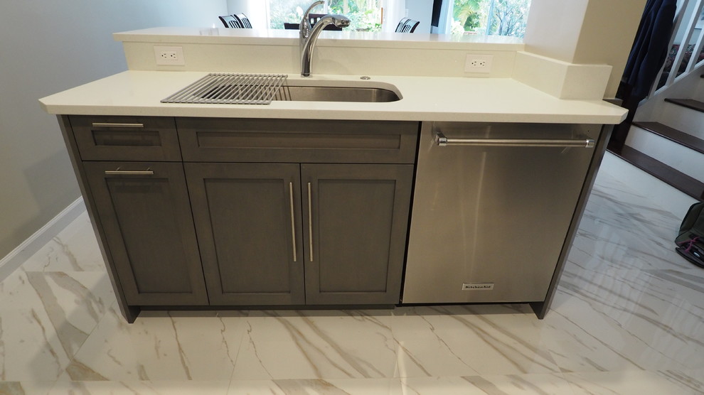 Inspiration for a mid-sized transitional galley porcelain tile eat-in kitchen remodel in Miami with a single-bowl sink, shaker cabinets, gray cabinets, quartzite countertops, white backsplash, stone slab backsplash, stainless steel appliances and an island