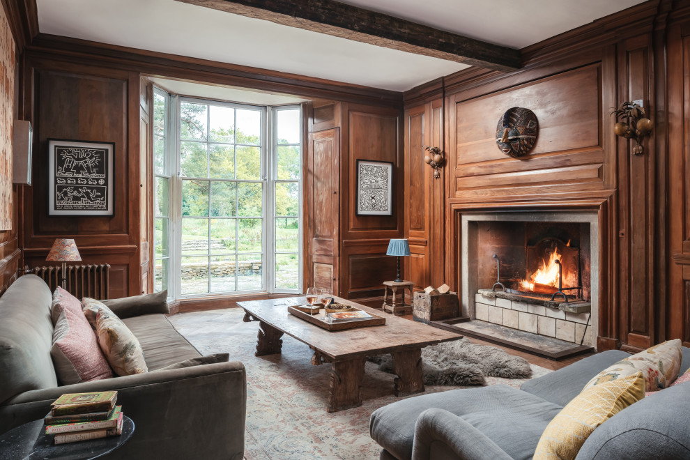 Idée de décoration pour un grand salon tradition en bois fermé avec une salle de réception, une cheminée standard, un manteau de cheminée en pierre et poutres apparentes.