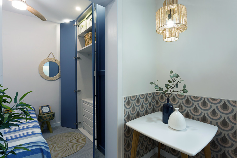 На фото: маленькая гардеробная в стиле модернизм с открытыми фасадами, синими фасадами, светлым паркетным полом и серым полом для на участке и в саду с