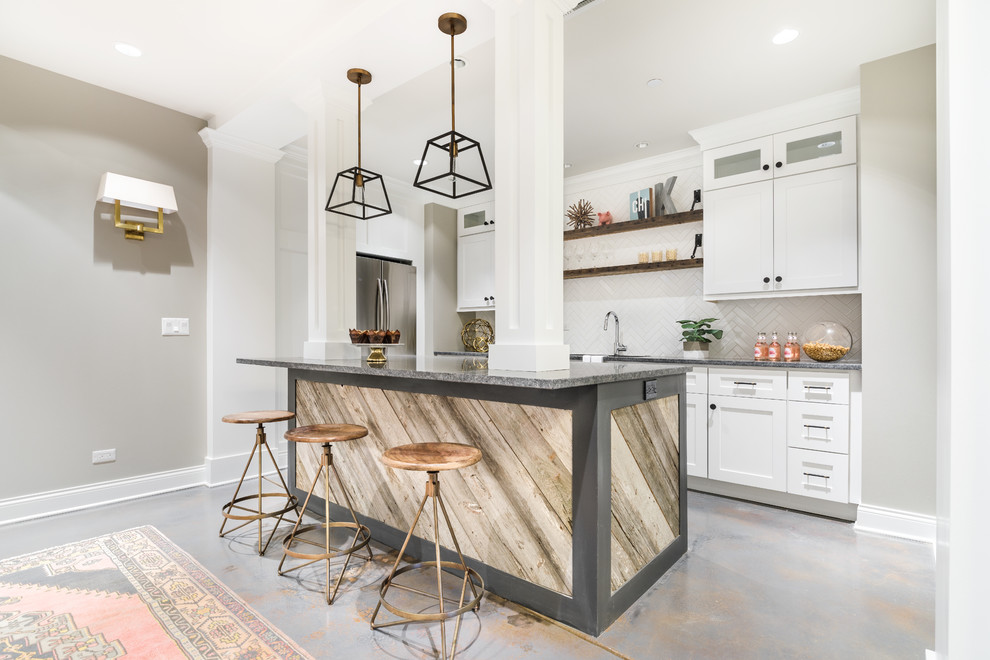 Inspiration for a mid-sized industrial l-shaped open plan kitchen in Chicago with a double-bowl sink, shaker cabinets, white cabinets, granite benchtops, white splashback, subway tile splashback, stainless steel appliances, cement tiles and with island.