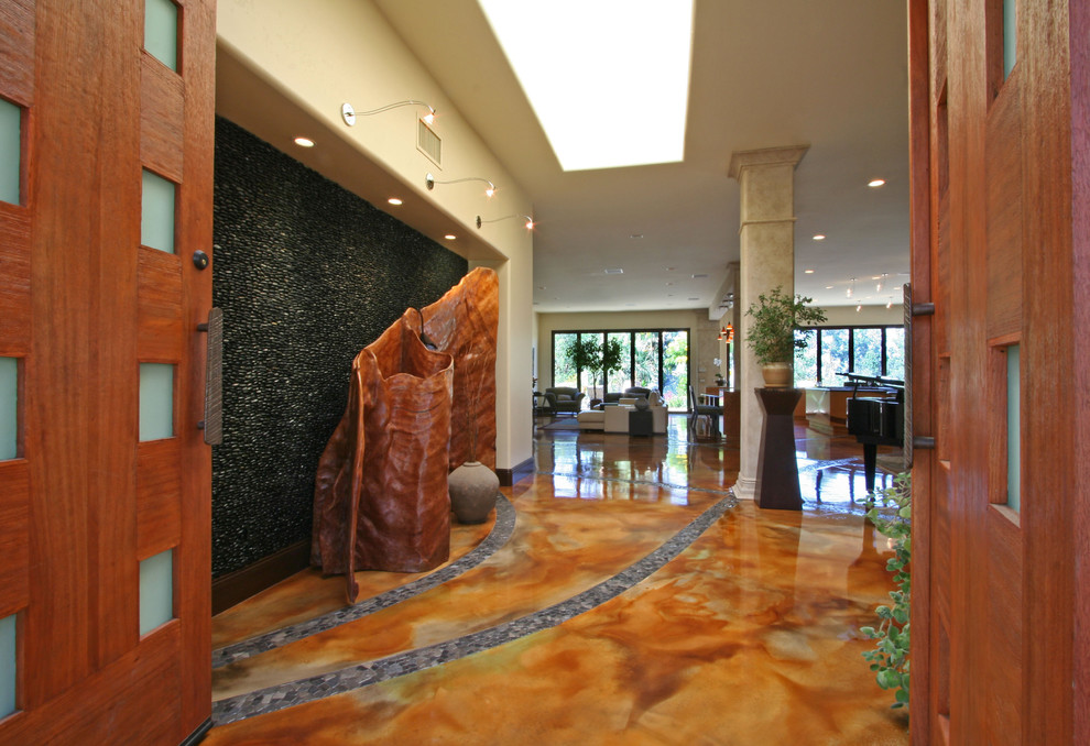 Huge transitional concrete floor and multicolored floor foyer photo in San Diego with beige walls and a medium wood front door