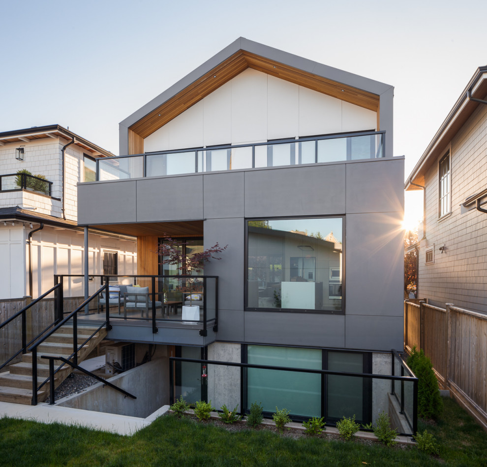 Mittelgroßes, Dreistöckiges Modernes Einfamilienhaus mit Faserzement-Fassade, weißer Fassadenfarbe, Satteldach, Blechdach, grauem Dach und Verschalung in Vancouver