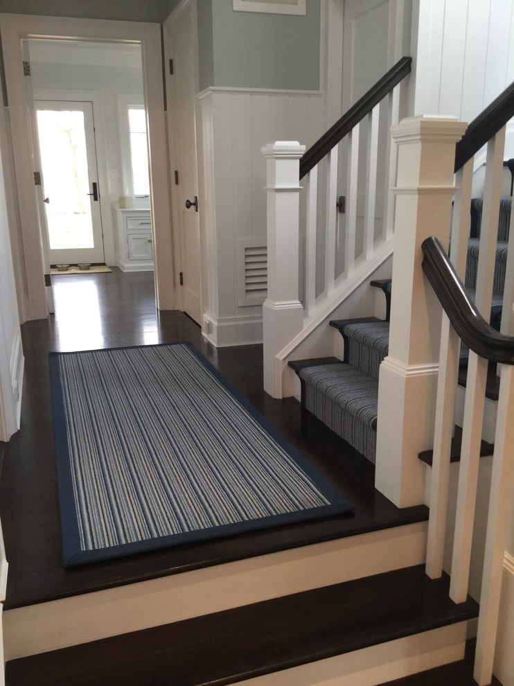 Photo of a mid-sized beach style hallway in New York with grey walls and dark hardwood floors.