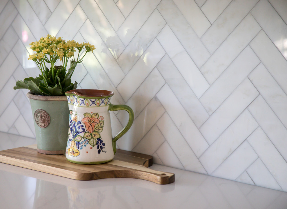 Inspiration for a large transitional galley medium tone wood floor and brown floor open concept kitchen remodel in Denver with an undermount sink, shaker cabinets, white cabinets, quartz countertops, beige backsplash, marble backsplash, stainless steel appliances, an island and white countertops