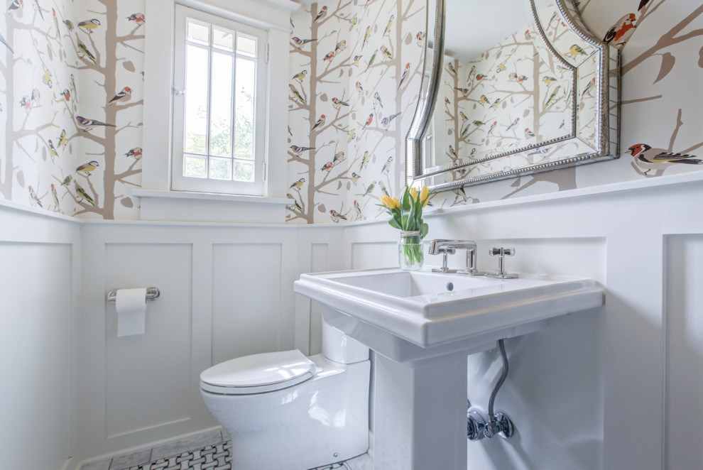 This is an example of a small traditional powder room in Denver with a two-piece toilet, multi-coloured walls, mosaic tile floors, a pedestal sink, a freestanding vanity and wallpaper.