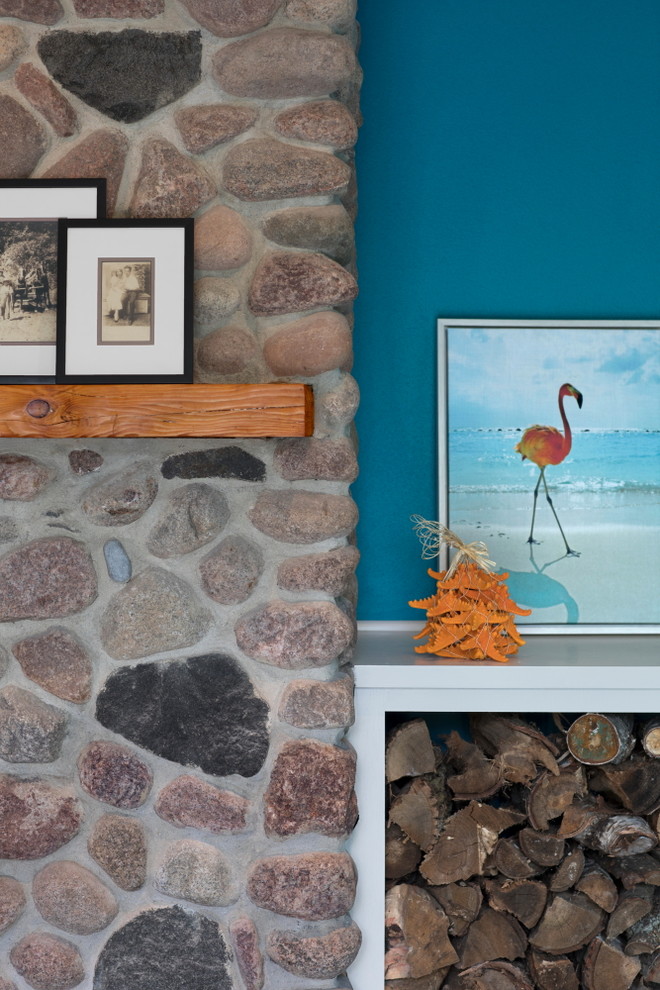 Design ideas for a mid-sized beach style open concept family room in Milwaukee with blue walls, vinyl floors, a standard fireplace, a stone fireplace surround, a wall-mounted tv and brown floor.