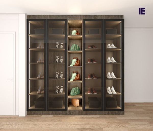 Photo of a large modern built-in wardrobe in London with glass-front cabinets, brown cabinets, plywood floors and brown floor.