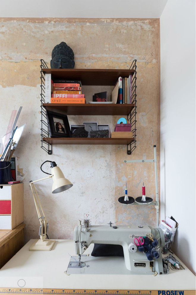 Inspiration for a small contemporary craft room in London with multi-coloured walls, medium hardwood floors, a freestanding desk and brown floor.