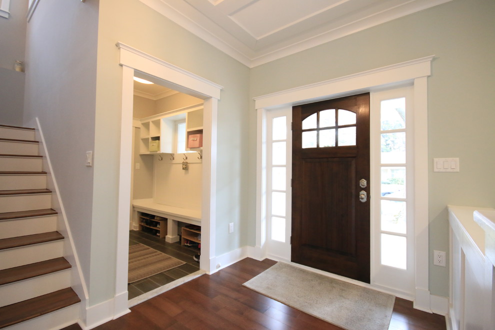 This is an example of an arts and crafts foyer in DC Metro with blue walls, dark hardwood floors, a single front door, a dark wood front door and brown floor.