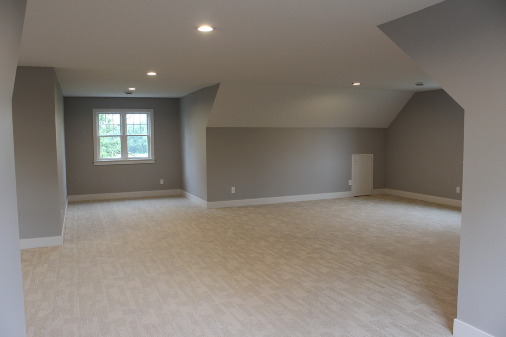 This is an example of a large transitional gender-neutral kids' room in Other with grey walls, carpet and beige floor.