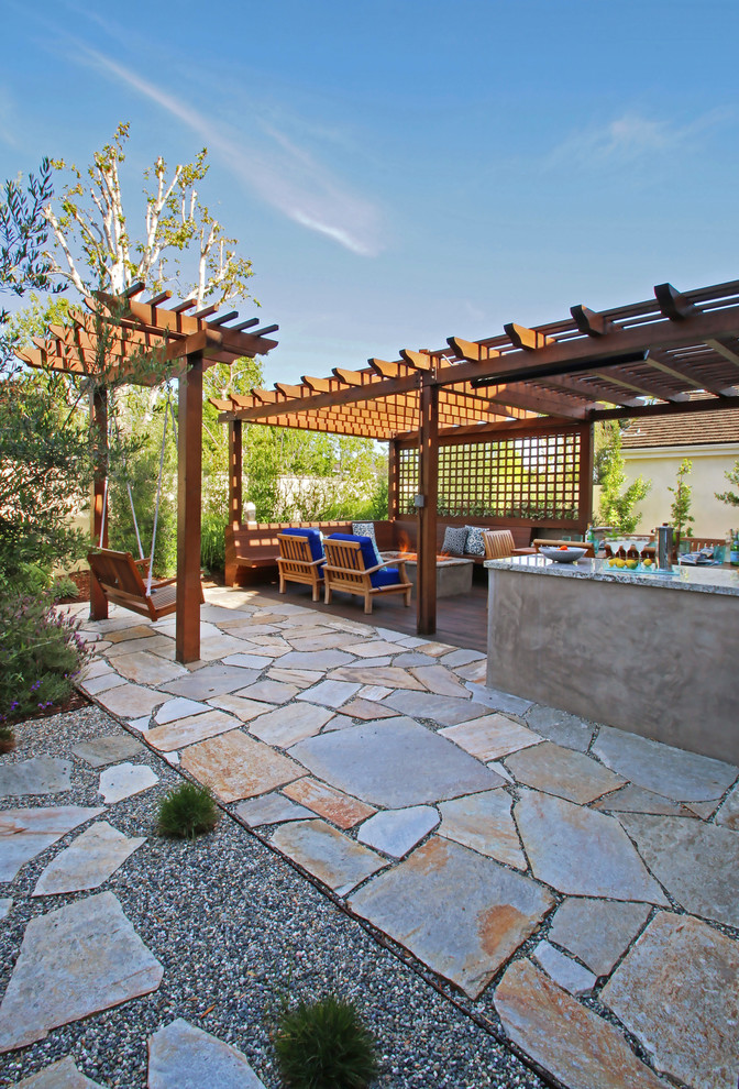 Mid-sized contemporary backyard patio in Los Angeles with a fire feature and natural stone pavers.