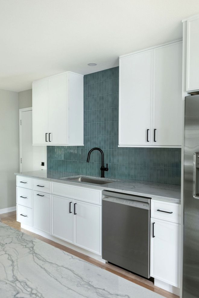 Mid-sized transitional galley light wood floor and yellow floor eat-in kitchen photo in Austin with an undermount sink, shaker cabinets, white cabinets, quartzite countertops, blue backsplash, subway tile backsplash, stainless steel appliances, a peninsula and gray countertops
