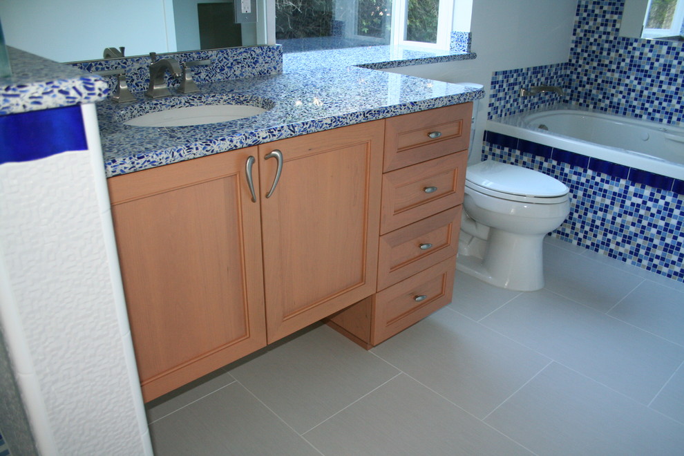 Design ideas for a transitional bathroom in San Francisco with an undermount sink, recessed-panel cabinets, medium wood cabinets, recycled glass benchtops, a drop-in tub, an open shower, a two-piece toilet and blue tile.